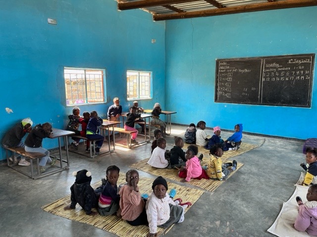 Nursery children in a blue walled classroom