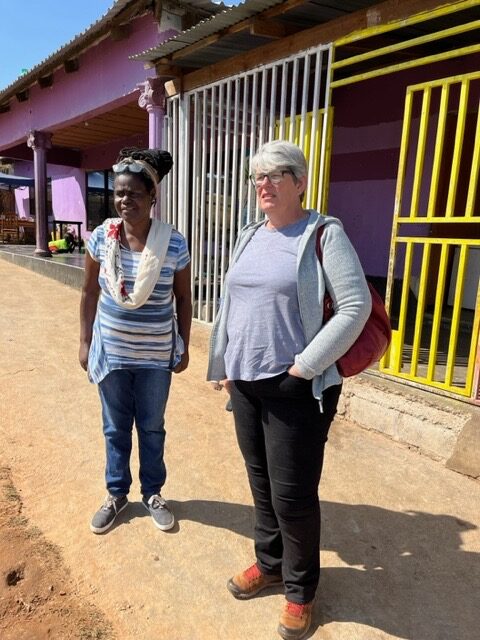 Jeannie Mulenga and Helen Ayles standing outside the Heal Project Transit House