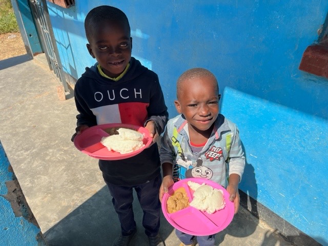 Smiling children with their lunch on plastic plates